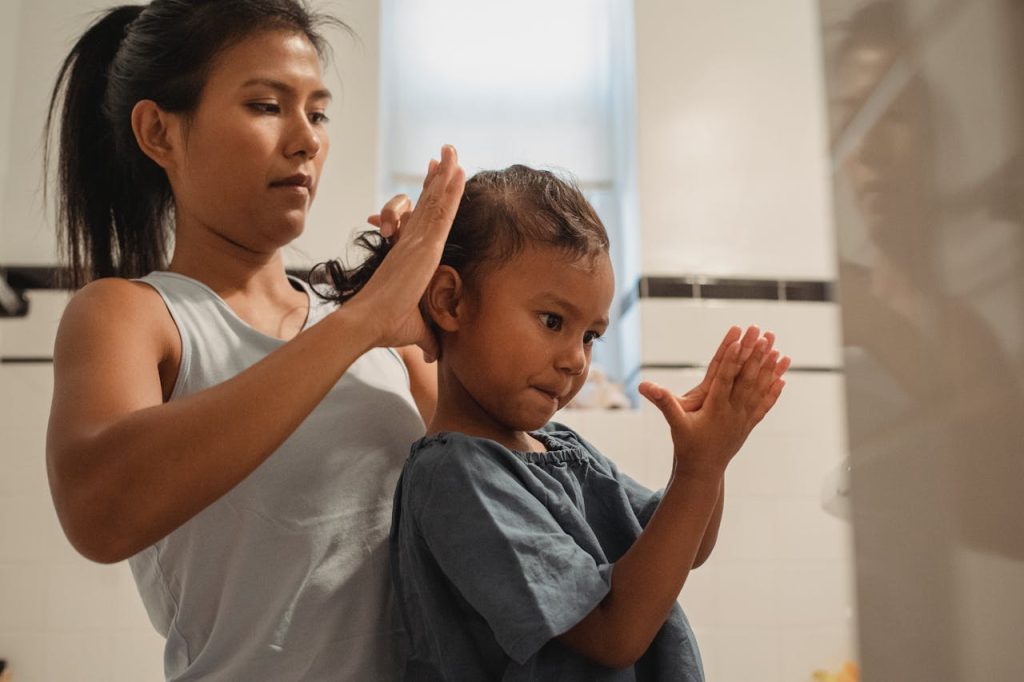 pexels-photo-5093680 Side view of focused young Hispanic mother braiding hair of cute little girl
